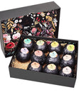 An open gift box filled with individually wrapped grace & stella bath bombs displayed on a bed of straw.