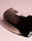 A smudged streak of Grace & Stella blackhead removal peel off mask on a pink background.