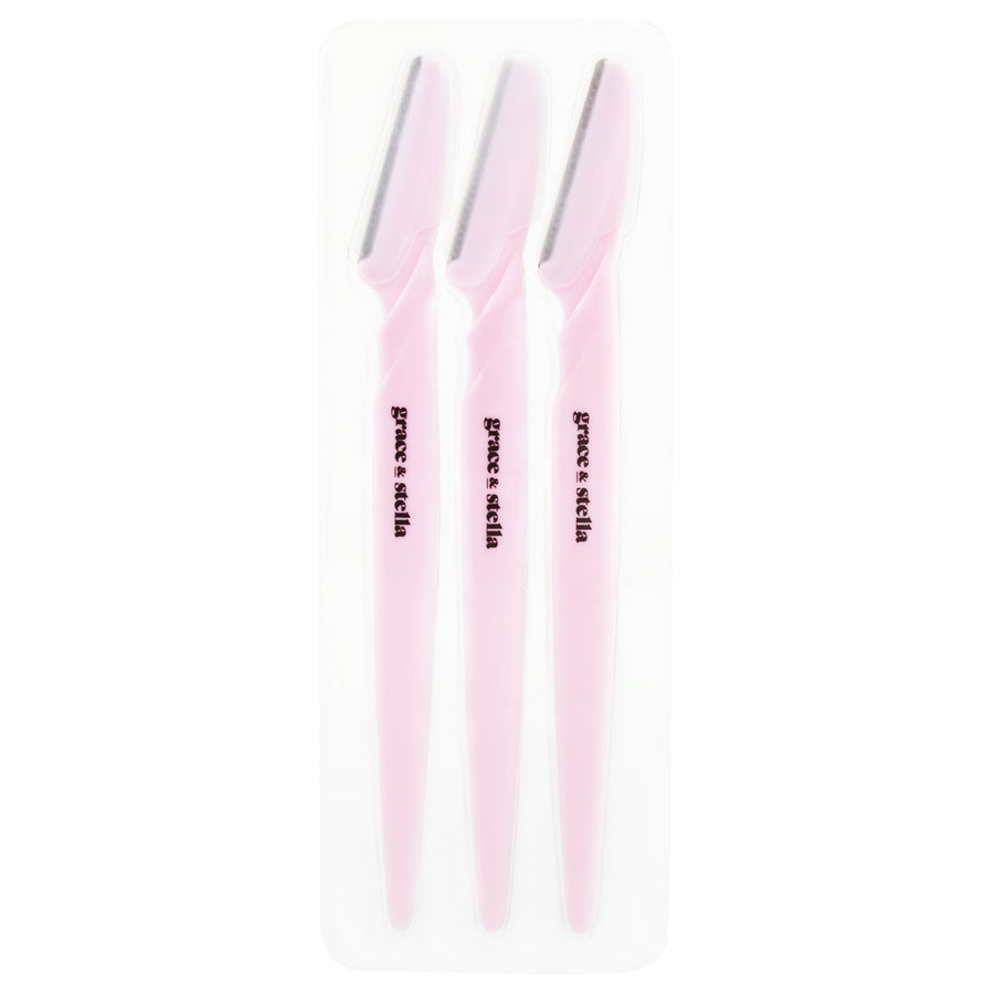Three pink grace & stella dermaplaning tools in plastic packaging, ideal for facial exfoliation and removing peach fuzz.