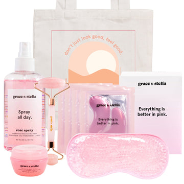 A collection of pink-themed beauty products including the Grace & Stella La Vie En Rose Set, with a fresh rose spray, a facial roller, and an eye mask, all packaged in a tote bag.
