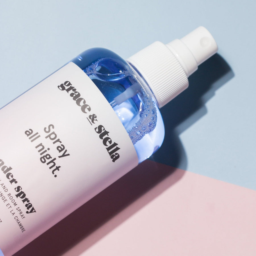 A bottle of grace & stella lavender spray on a dual-toned pink and blue background.