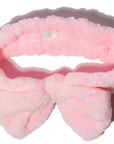 Pink fluffy bow headband and grace & stella co. silicone face mask applicator brushes on a white background.
