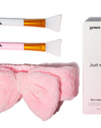 Facial mask application set with two Grace & Stella Co. silicone face mask brushes and a pink headband next to its packaging.