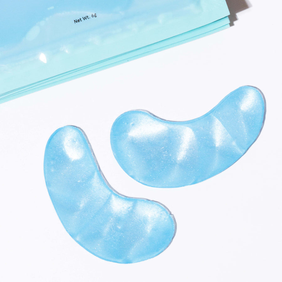 Two grace & stella blue eye masks on a white surface, hydrating and soothing tired eyes.