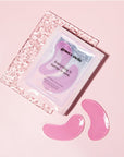 Two grace & stella pink firming hydrogel eye masks beside their packaging on a pastel background.