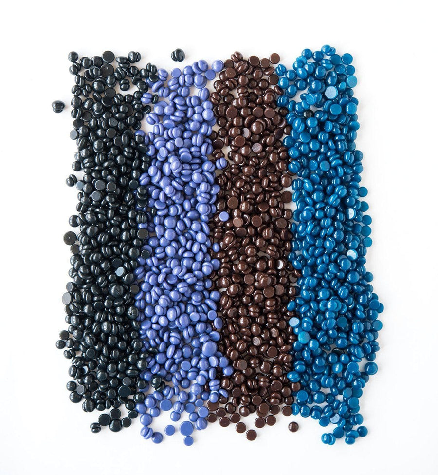 Assorted blue and brown beads on a white background, grace & stella wax kit free gift.